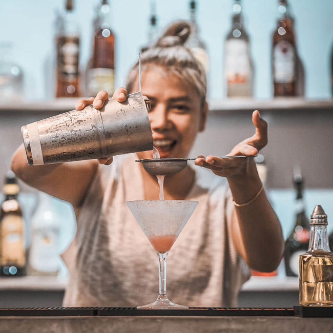 girl straining a cocktail